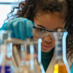Jovem aluna explora o que são ciências biológicas estudando o conteúdo em diferentes beckers.